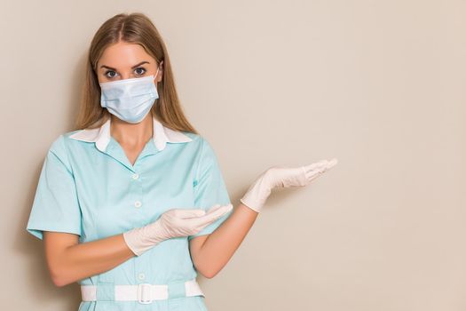 Portrait of nurse with protective mask gesturing.