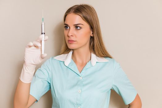 Portrait of medical nurse holding injection.