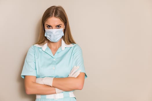 Portrait of angry nurse with protective mask and gloves.