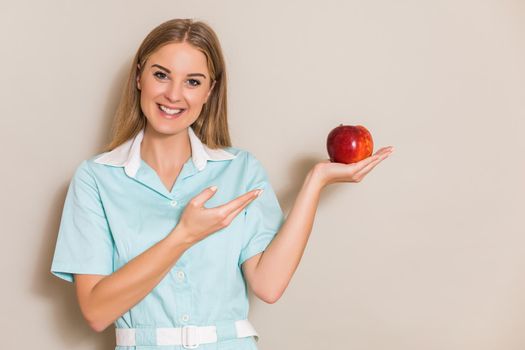 Portrait of  medical nurse holding apple.