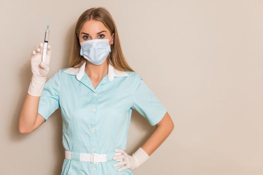 Portrait of nurse with protective mask  holding injection.