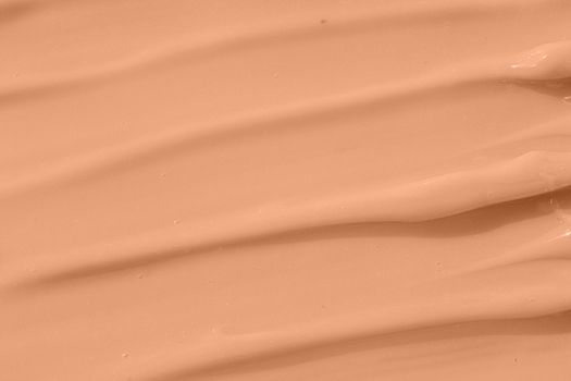 Cosmetic tonal moisturizer, bb cream swatch sample. Beige nude liquid foundation texture, concealer smear smudge drop. Make up base, cream textured background. Closeup macro