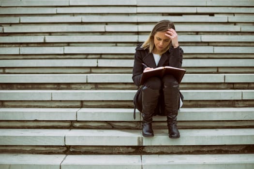 Worried businesswoman working outdoor.