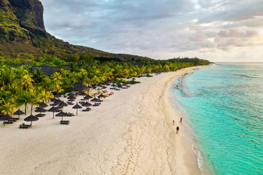 View from the height of the island of Mauritius in the Indian Ocean and the beach of Le Morne-Brabant and the family on the beach.