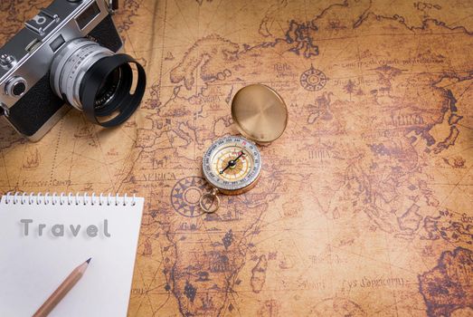 Vintage Compass and camera on map for travel planning