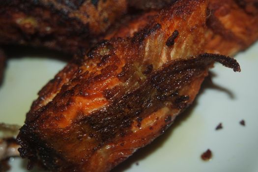 Spicy and crunchy barbecue of fried fish fillet on a white background. Homemade grilled trout fish steaks for health nourishments.