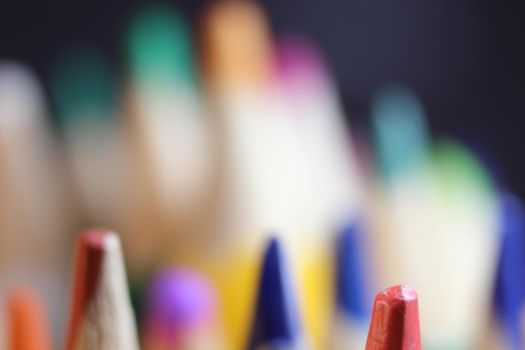 Close-up view of bright colored multicolor pencils on black background