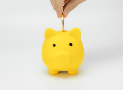 Hand saving money in piggy bank