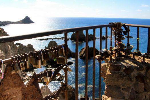 Romantic padlocks hanging on The Reef of the Sirens railing in Cabo de Gata-Nijar, Almeria, Spain