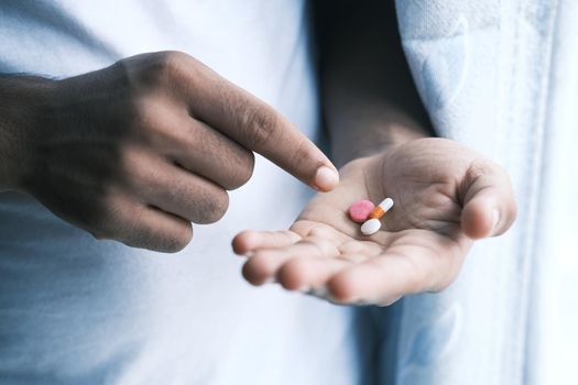 man's hand with pills spilled out of the container .