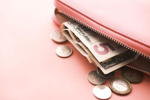 us dollar cash in leather on pink background .