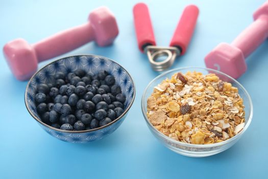 cereal breakfast, blue berry in bowl and dumbbell on table ,