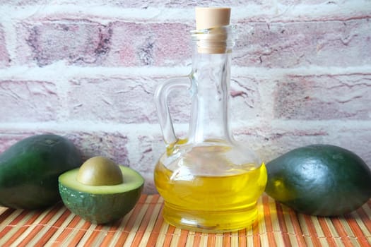 oil and slice of avocado on wooden table .