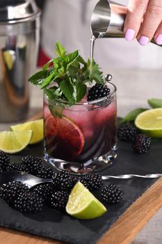 Blackberry summer mojito cocktail. Cold refreshing organic alcoholic drink with berries, lime, mint 