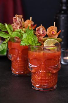 Creepy Halloween party - Caesar or Bloody Mary cocktail containing vodka, some tomato juice, different spices and flavorings, such as Worcestershire sauce, celery. Served with ice in a beer glass 