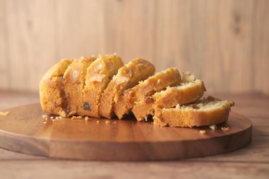 slice of bakery fruit cake on chopping board ,