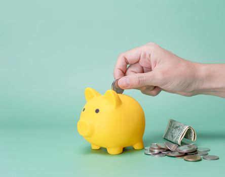 Hand saving money in piggy bank