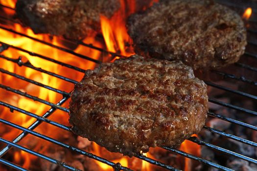 Close up beef or pork meat barbecue burgers for hamburger prepared grilled on bbq fire flame grill, high angle view