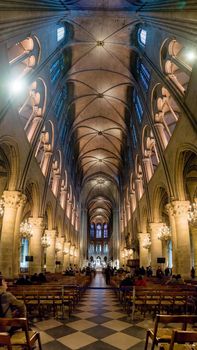 Paris, France - February 3, 2017: Interior of the Notre Dame de Paris, France. Tall vertical view looking down the main aisle