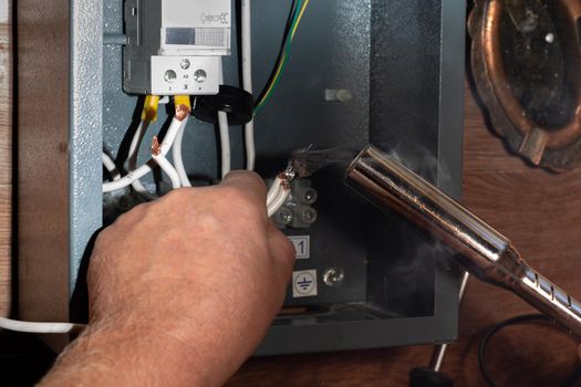 Soldering the elements of the electrical circuit of the heating system of the cottage.