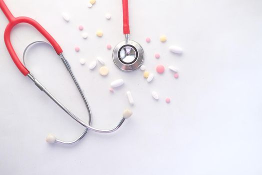medical pills and stethoscope on white background .