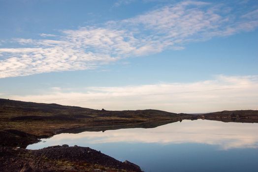 Atmospheric Iceland landscape with blue sky and clouds reflected on water