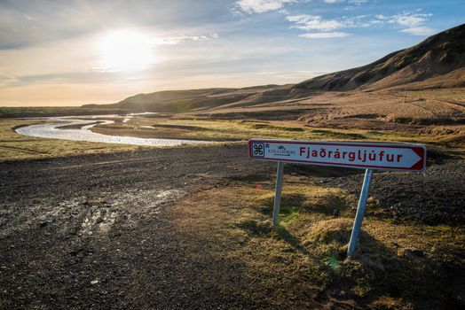 Signage for Fjaorargljufur, Iceland mossy green canyon at sunset with golden landscape