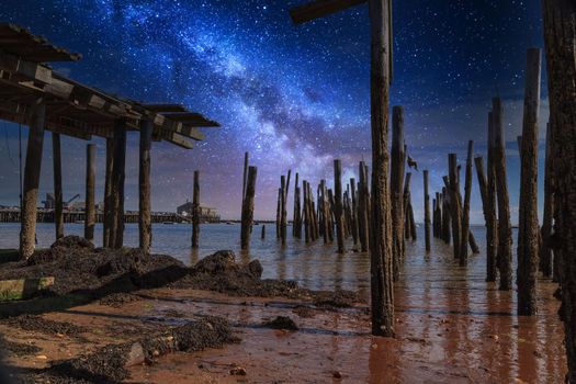 Stary sky milky way over a dilapidated old pier in Provincetown, Cape Cod, Massachusetts at night.