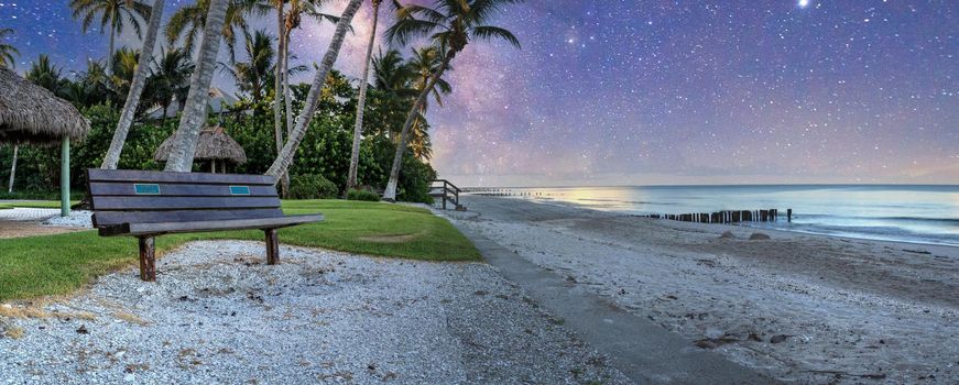 Milky way over Bench overlooking the ocean at Port Royal Beach in Naples, Florida at sunrise.