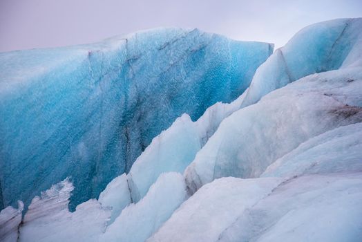 Detail Icelandic glacier image bright blue glacier abstract closeup texture image with black lines from volcanic ash