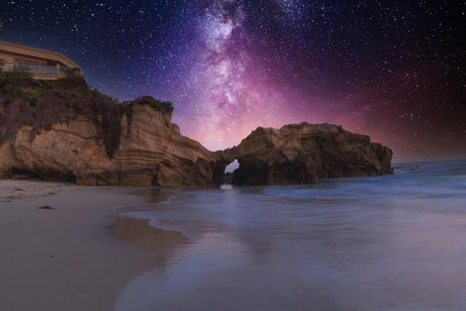 Stary night over Pearl Street Beach rock formation at just after sunset in Laguna Beach, California.