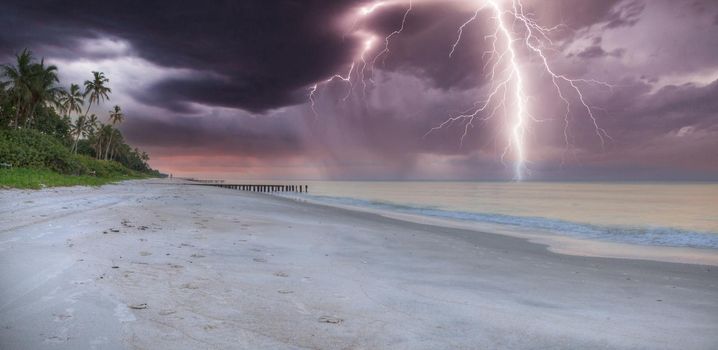 Lightning storm over the ocean at Port Royal Beach in Naples, Florida at sunrise.