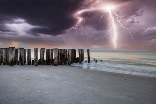 Lightning storm over the ocean at Port Royal Beach in Naples, Florida at sunrise.