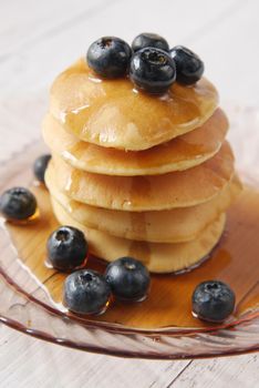 Pancakes with fresh berries and maple syrup on a plate