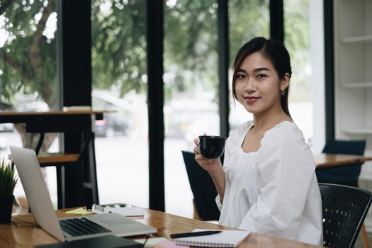 Photo of gorgeous secretary working at office. she sitting at the wooden desk.