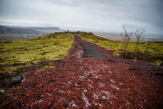 Magical Iceland terrain with deep red and green textures with a black path into the distance mysterious atmosphere serene surreal magic