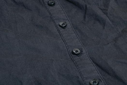 Buttons on a black shirt close up, macro photo