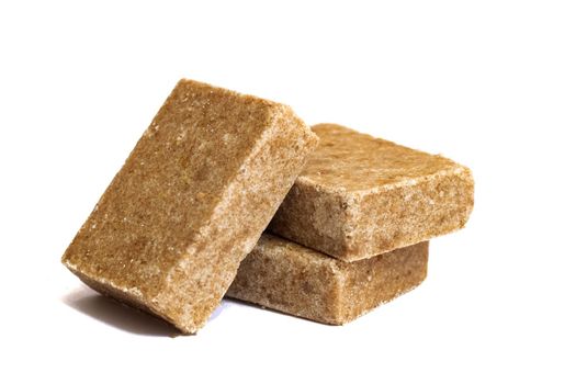 Three yellow bouillon cubes isolated on a white background