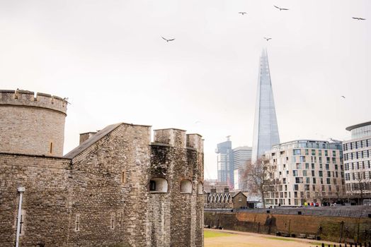 London, UK - January 26, 2017: Abstract landscape view of Tower of London and the Shard with birds flying around the geometric shapes.