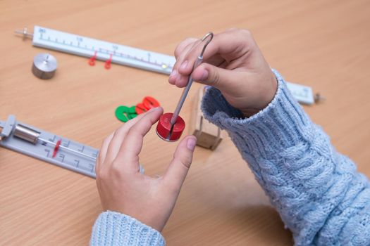 Close-up of hands holding physical model. A schoolboy performs a task at the workplace. The concept of children's education, teaching knowledge, skills and abilities.