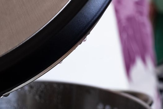 Open black electric kettle with water drops close up