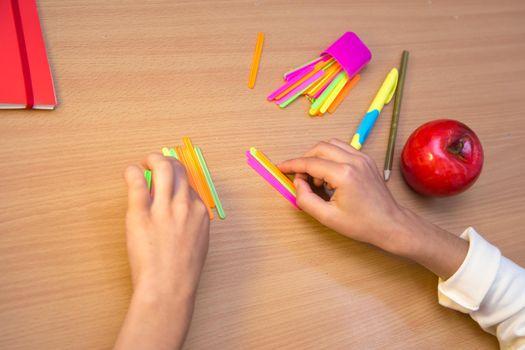 A student at a desk studies math counting with sticks. A schoolboy performs a task at the workplace. The concept of children's education, teaching knowledge, skills and abilities.