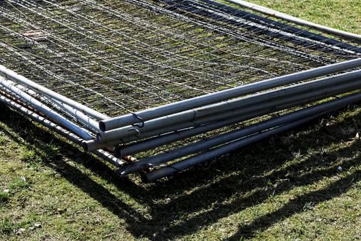 Metal fence mesh folded on the grass close up