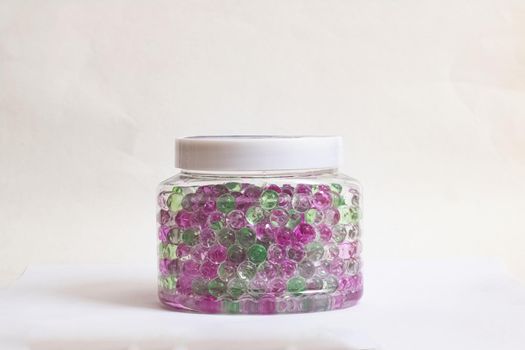 Jar with colored balls of air freshener on gray background