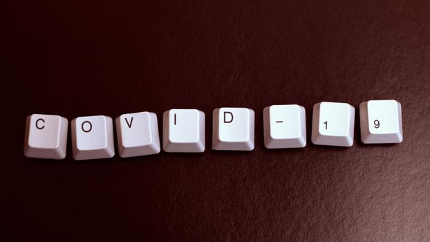 The word Covid-19 from the keyboard keys on red background