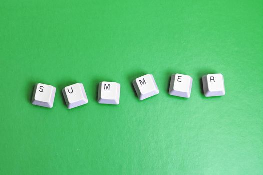 Word summer made of cubes on a green background close up