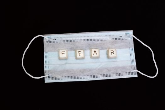The word fear made of keys on a medical mask