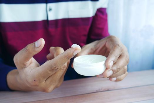 Close up of man hand using petroleum jelly .