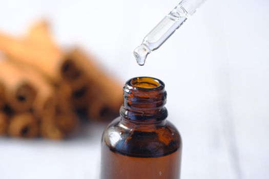 dropping cinnamon essential oil in a container