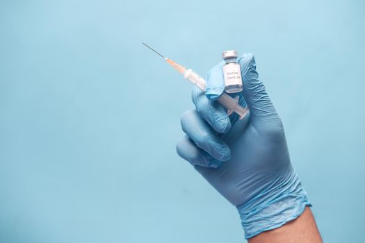doctor hand in gloves holding coronavirus vaccine, close u.